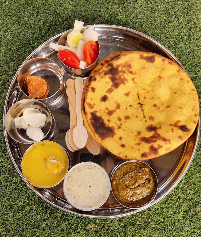 A delicious assortment of traditional Indian foods served on a silver plate, showcasing vibrant flavors.